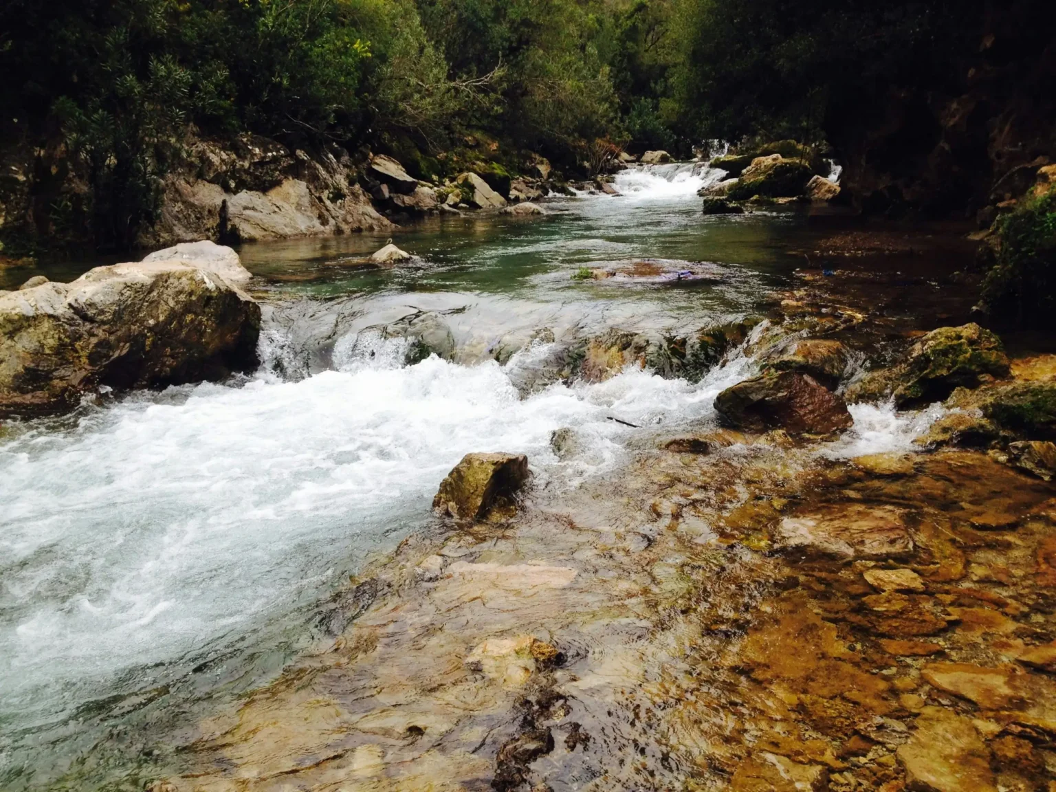 A beautiful river with cascading waters and rocky landscape in Akchour, Morocco.