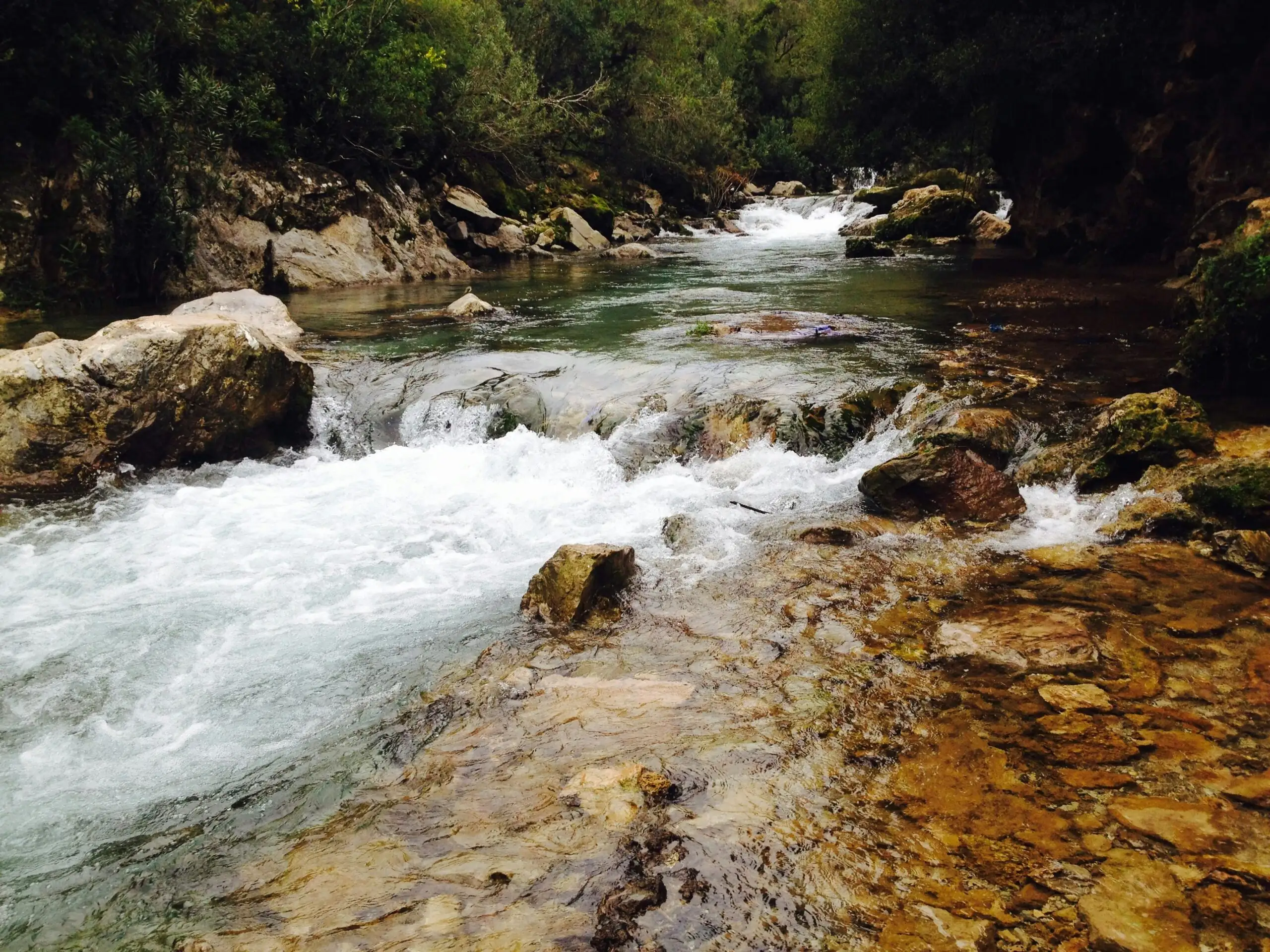 A beautiful river with cascading waters and rocky landscape in Akchour, Morocco.